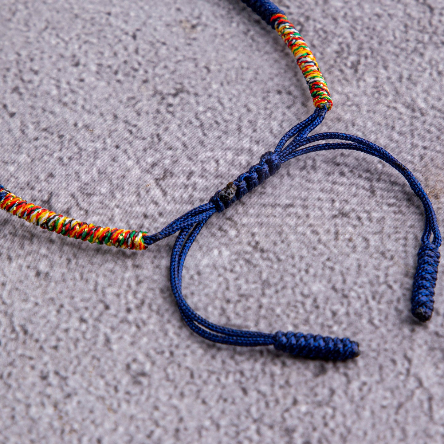 Midnight Kaleidoscope: Dark Blue Bracelet with Multicolor Thread Accents